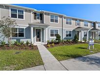 Charming multi-Gathering townhouse featuring a well-manicured lawn and neutral two-tone exterior at 3213 Douglas Fir Dr, Apopka, FL 32703