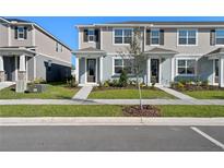 Charming two-story townhome featuring a welcoming entrance and well-maintained landscaping on a sunny day at 3229 Douglas Fir Dr, Apopka, FL 32703