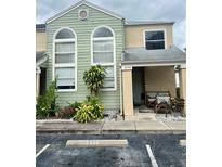 Inviting two-story townhome featuring a covered porch, manicured landscaping, and convenient parking at 2444 Summerfield Way # 1, Kissimmee, FL 34741