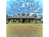 Charming single-story home features a welcoming front porch and lush lawn at 33412 E Lake Joanna Dr, Eustis, FL 32736