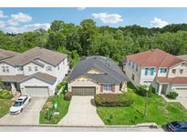 Aerial view of a two-story house with a two-car garage and a well-manicured lawn at 273 Willow View Dr, Davenport, FL 33896