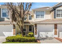 Charming townhome exterior with stone accents, attached garage, and well-maintained landscaping at 524 Hockendale Cv, Sanford, FL 32771