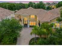 Two-story house with tile roof, large windows, and a three-car garage at 334 Chadwick Dr, Davenport, FL 33837