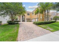 Elegant two-story home featuring a paver driveway, manicured landscaping, and a two-car garage at 334 Chadwick Dr, Davenport, FL 33837