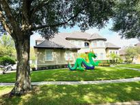 Charming home featuring a well-manicured lawn and a whimsical dragon decoration, adding a touch of fun at 8734 Crestgate Cir, Orlando, FL 32819