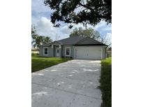 Charming single-story home featuring a well-manicured lawn, a two-car garage, and a welcoming front entrance at 1780 Converse Ct, Deltona, FL 32738