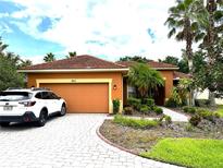 Charming single-story home with a well-manicured lawn, paver driveway, and a two-car garage at 681 Coronado Dr, Kissimmee, FL 34759