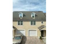 Well-maintained townhome with brick driveway, attached garages, and dormer windows providing natural light at 3432 Westchester Square Blvd # 205, Orlando, FL 32835