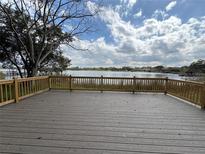 A spacious deck overlooks a serene lake, offering a perfect spot for relaxation and outdoor enjoyment at 4808 Anderson Rd, Orlando, FL 32812