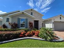 Charming home exterior featuring manicured landscaping and colorful flower beds at 840 Jasmine Creek Rd, Kissimmee, FL 34759