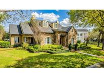 Two-story stone house with manicured lawn and landscaping at 222 Acadia Ter, Celebration, FL 34747