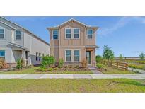 Charming two-story home featuring manicured lawn and stone landscaping in the front yard at 1231 Teal Creek Dr, St Cloud, FL 34771