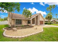 Charming single-story home featuring a brick facade, neutral stucco, an attached two car garage and manicured landscaping at 1121 Trotwood Blvd, Winter Springs, FL 32708