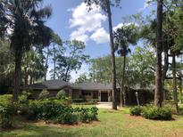 Charming single-story brick home with a well-manicured lawn, mature trees, and a welcoming double-door entrance at 5100 Linwood Cir, Sanford, FL 32771