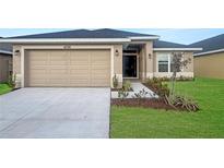 New single-story home with a two-car garage and landscaped front yard at 4376 Sagefield Dr, Harmony, FL 34773