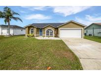 Charming single-story home with a well-manicured lawn and a two-car garage at 7856 Habersham Dr, Lakeland, FL 33810