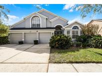 Charming two-story home featuring a three-car garage and well-manicured landscaping at 10434 Stone Glen Dr, Orlando, FL 32825