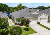 Beautiful home exterior with two-car garage, well-kept lawn, and vibrant landscaping at 118 Lower Lake Ct, Debary, FL 32713