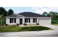 Charming single-story home featuring a well-manicured lawn and attached two-car garage at 3911 Gardenia Dr, Indian Lake Estates, FL 33855