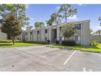 Exterior view of a condo building with parking spaces and landscaping at 115 Springwood Cir # C, Longwood, FL 32750