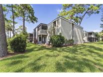 Exterior view of a two-story condo building with a balcony and well-maintained lawn at 115 Springwood Cir # C, Longwood, FL 32750