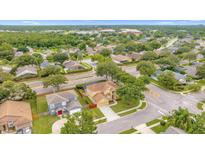 A neighborhood featuring two-story homes with mature trees and well-maintained lawns are shown in an aerial view at 2780 Running Springs Loop, Oviedo, FL 32765