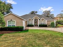 Charming single story home featuring a manicured lawn and mature landscaping at 404 Hightower Dr, Debary, FL 32713