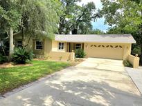 Charming single Gathering home with a large driveway and attached garage, landscaped yard and mature trees at 425 E Hillcrest St, Altamonte Springs, FL 32701
