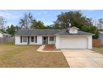 One-story house with attached garage and landscaped front yard at 2495 Sedgefield Ave, Deltona, FL 32725