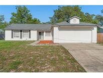 Charming single-story home with white siding, dark shutters, and a well-maintained front yard at 2495 Sedgefield Ave, Deltona, FL 32725
