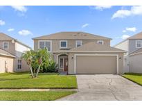 Charming two-story home with a well-manicured lawn and mature palm trees at 132 Spanish Bay Dr, Sanford, FL 32771