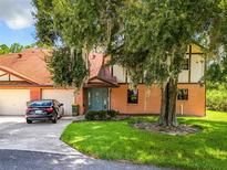 Charming two-story home with brick accents, mature tree, and well-maintained lawn and attached two car garage at 100 E Oak Terrace Dr # G1, Leesburg, FL 34748