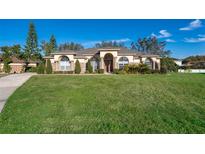 Single-story home exterior with manicured lawn and walkway at 13707 Calle De Ora Ct, Clermont, FL 34711