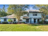 Charming townhome featuring a well-maintained lawn, mature trees, and a classic two-story facade at 2722 Graduate Ct, Orlando, FL 32826