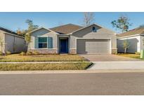 Charming single-Gathering home featuring stone accents, neutral color palette, well-manicured lawn, and a two-car garage at 349 River Front Way, Edgewater, FL 32141