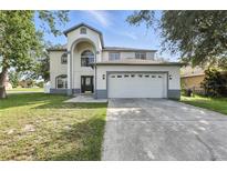 Charming two-story home with a well-maintained lawn, attached two car garage, and beautiful curb appeal at 724 Tahiti Dr, Kissimmee, FL 34758