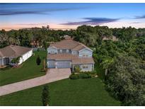 Beautiful two-story home with a three-car garage, lush landscaping, and a brick driveway at 708 Fox Edge Ct, Oviedo, FL 32765