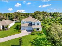 Beautiful two-story home with manicured lawn, three car garage, and charming architectural details at 708 Fox Edge Ct, Oviedo, FL 32765