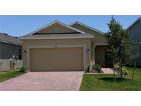 Charming single-story home features a brick driveway, attached two-car garage, and well-maintained landscaping at 1926 Church Lake St, Groveland, FL 34736