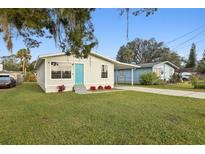 Charming single-story home featuring a well-manicured lawn and a bright blue front door at 610 Walker St, Holly Hill, FL 32117