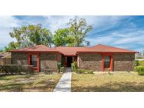 Charming single-story brick home with a well-manicured lawn and mature trees at 1546 Stormway Ct, Apopka, FL 32712