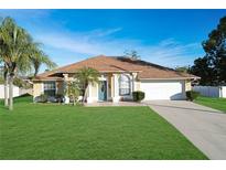 Single-story house with a two-car garage and a well-manicured lawn at 1053 Abadan Dr, Deltona, FL 32725