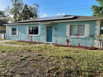 Charming blue home featuring a well-manicured lawn, solar panels, and classic white shutters at 3804 Janie Ct, Orlando, FL 32822