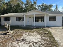 Charming single-story home featuring a covered front porch, white exterior paint, and neat landscaping at 605 Plum Ln, Altamonte Springs, FL 32701