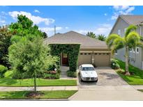 Charming home with a brick driveway, lush greenery, and a two-car garage at 16161 Parkwyn St, Winter Garden, FL 34787