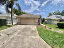 Charming single Gathering home with well-maintained lawn, front yard, and two car garage at 5610 King James Ave, Leesburg, FL 34748