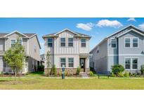 Charming two-story home featuring stone accents, landscaping, and a well-maintained green lawn at 1211 Teal Creek Dr, St Cloud, FL 34771
