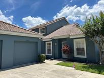 Charming single-story home boasts a well-maintained lawn, attached garage and clay tile roof at 4559 Oak Arbor Cir, Orlando, FL 32808