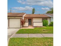Charming single story home with a well-manicured lawn and attached one car garage at 5875 Talavera St, Orlando, FL 32807