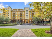 Luxury condo building with multiple floors, balconies, and ample parking at 8112 Poinciana Blvd # 1305, Orlando, FL 32821